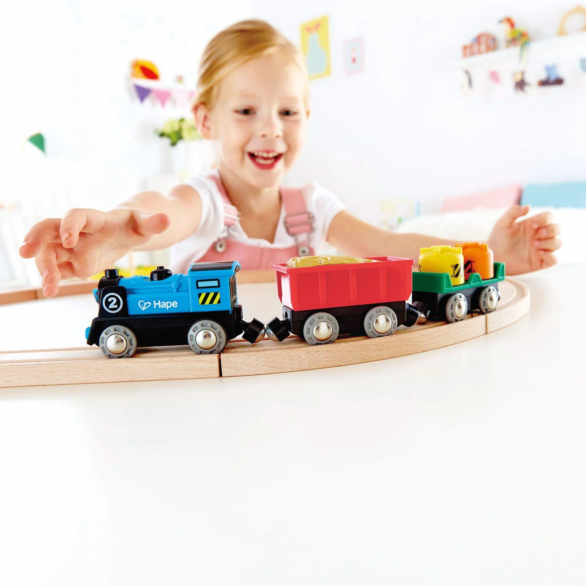 Hape Treno merci a batteria - Locomotiva giocattolo con due vagoni dotati di luci, effetti e giunti magnetici compatibili per gioco a tema ferrovia dai 3 anni